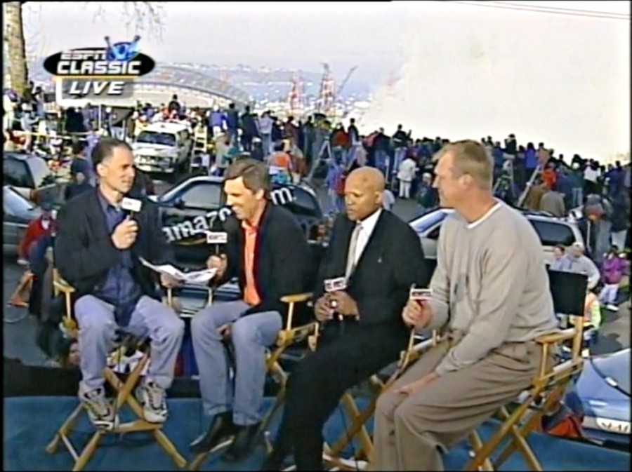 March 26, 2000:  SportsCenter anchor Kenny Mayne (left) is host of ESPN Classic's coverage of the implosion of the Seattle Kingdome.  His guests included Seattle sports stars (l to r): former  Seahawks quarterback Dave Krieg, former SuperSonics guard Slick Watts and former SuperSonics center Jack Sikma. The smoke from the implosion can be seen rising behind them.