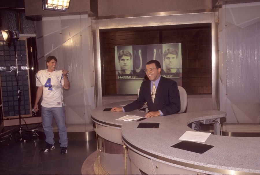 It's been a while since Mike Tirico (seated) has been on a SportsCenter set in Bristol, Conn. When he anchors the show in DC-2 on Sunday, he won't Jim Harbaugh - who was still an NFL quarterback in this 1995 shot from a "This Is SportsCenter" spot - as his wingman. (Patrick Flynn/ESPN Images)