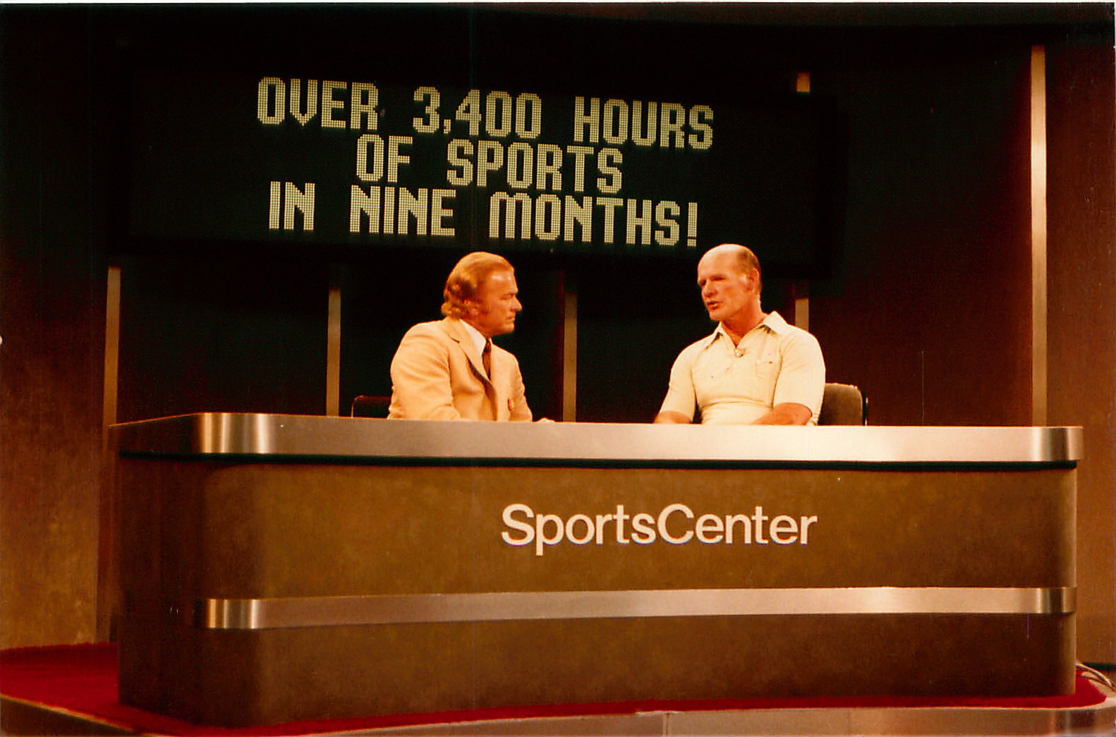 Dallas TX, May 1980: Jim Simpson (l) is shown talking with Dallas Cowboys coach Tom Landry on a SportsCenter set at the NCTA.