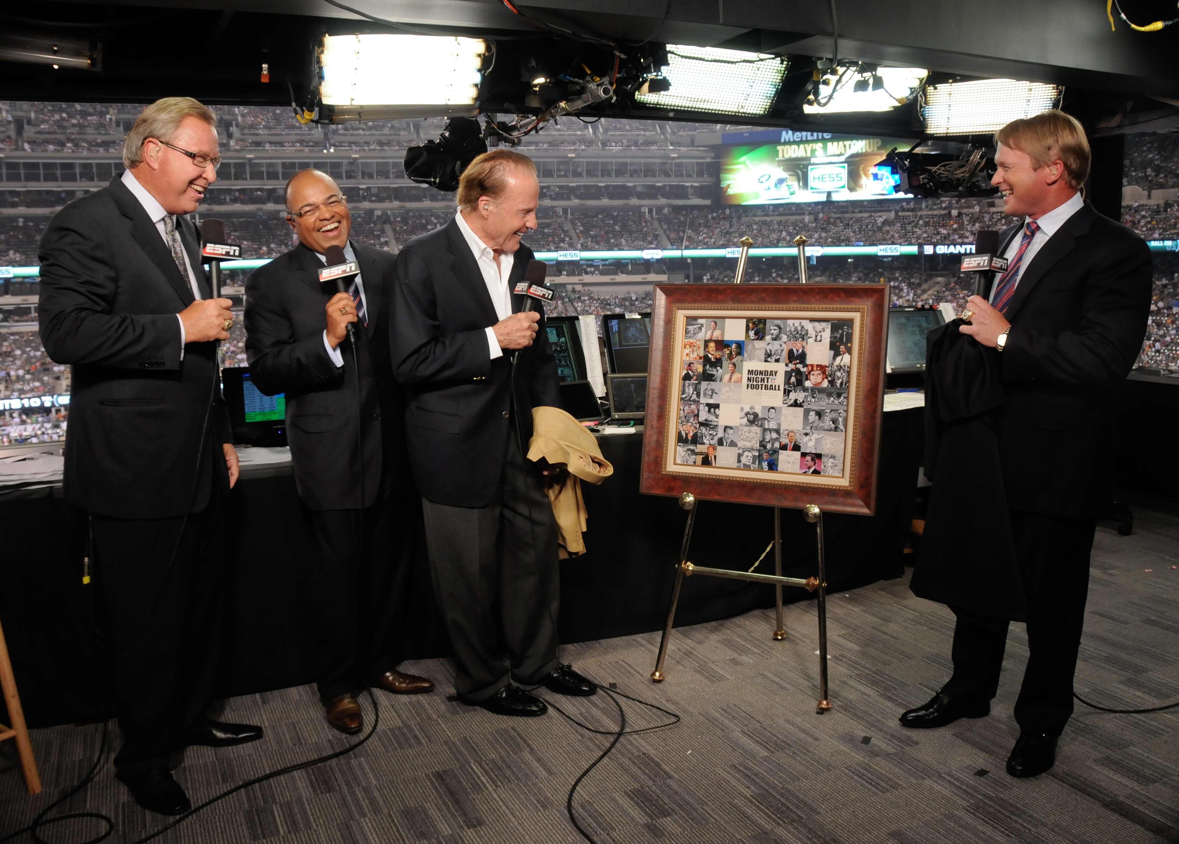 ESPN's Monday Night Football commentators (l to r) Ron Jaworski, Mike Tirico and Jon Gruden present Hall of Famer and former Giants' halfback Frank Gifford with an 80th birthday gift. (Ida Mae Astute/ESPN Images)
