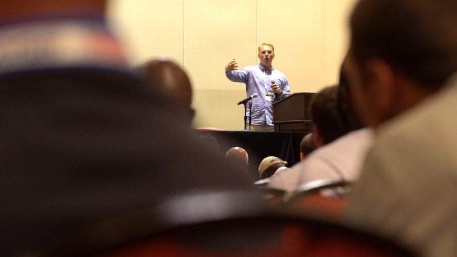 Former UConn quarterback Casey Cochran speaks at a coaches’ conference about taking concussion precautions.