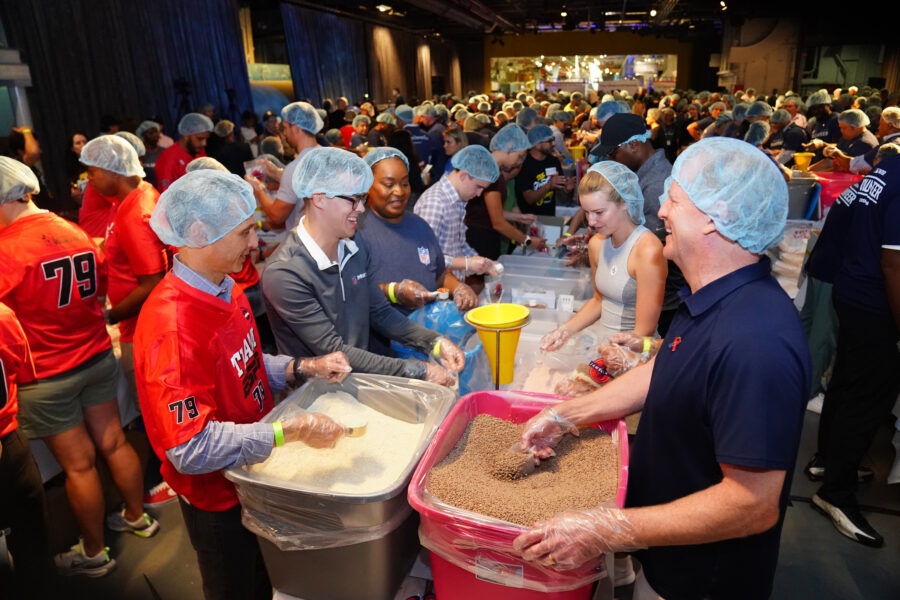 ESPN, Disney and NFL employees were among thousands of volunteers packing meals for families in need at the Intrepid Sea, Air & Space Museum in New York on Monday